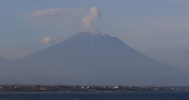Asap putih letusan Gunung Agung menyembur ke atas saat diabadikan dari Pantai Sanur, Senin (2/7) sore (Miftahuddin Halim/Radar Bali)