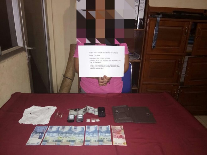 Tersangka Tuti saat diamankan bersama dengan barang bukti narkotika jenis sabu di Mapolres Batanghari, Senin (13/8).      