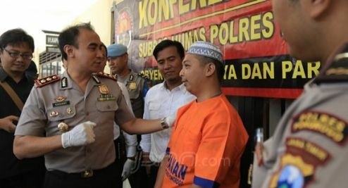 Tersangka pembunuhan ayahb kandung saat diamankan Polisi.