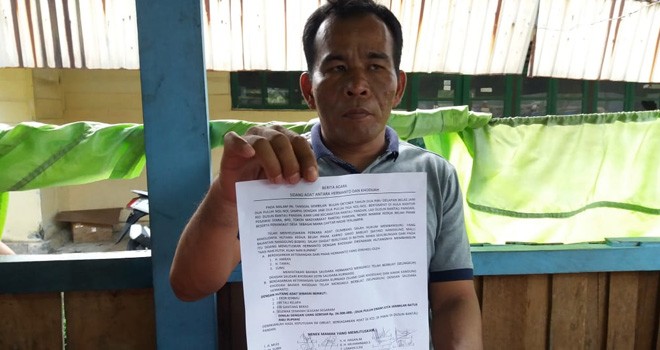 Rio Dusun Rantau Pandan, Kurniadi (45) saat memperlihatkan surat berita acara.