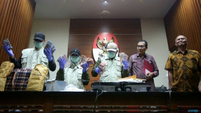 Ilustrasi: Penyidik KPK memperlihatkan barang bukti uang suap hasil operasi tangkap tangan (OTT) beberapa waktu lalu. (Mifathul Hayat/ Jawa Pos)