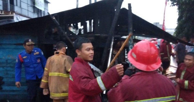 Petugas saat melakukan pendinginan di tempat tempel di Jalan Patimura, RT 2 Kelurahan Kenali Besar, Kecamatan Alam Barajo, Kota Jambi, yang terbakar Jumat (7/12) sore.