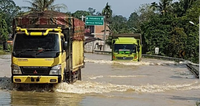 Mobil truk saat melewati badan jalan di Merlung yang terendam banjir. Foto : Gatot Sunarko / Jambi Update
