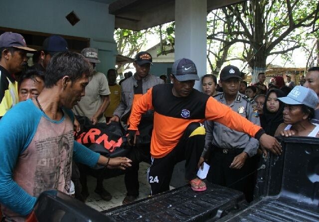 DIEVAKUASI: Tim SAR Rimba Laut bersama warga dan polisi saat melakukan evakuasi korban setelah berhasil ditolong dan dilarikan ke Kamar Mayat Puskesmas Sabrang, Ambulu (Jumai/Radar Jember)