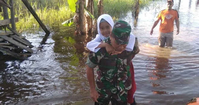 Babinsa Bantu Anak Sekolah saat Seberangi Banjir. Foto : Ist