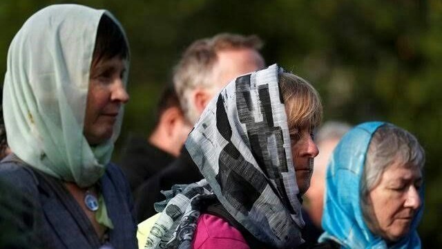 Para perempuan mengenakan hijab untuk menunjukkan dukungan mereka bagi umat Islam. Perdana Menteri Selandia Baru Jacinda Ardern memimpin ribuan pelayat yang berkumpul di Hagley Park di depan Masjid Al Noor, tempat sebagian besar korban meninggal (Reuters)