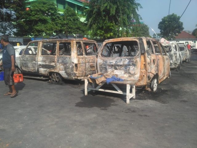 Massa yang anarkis membakar sejumlah mobil, Rabu (22/5). (Yogi Wahyu/Jawa Pos)