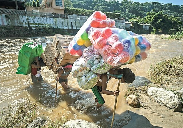 PERJUANGKAN NASIB: Rombongan pengungsi menyeberangi Sungai Suchiate dari El Carmen, Guatemala, menuju Chiapas State, Meksiko, Jumat (7/6). (Pedro Pardo/AFP)
