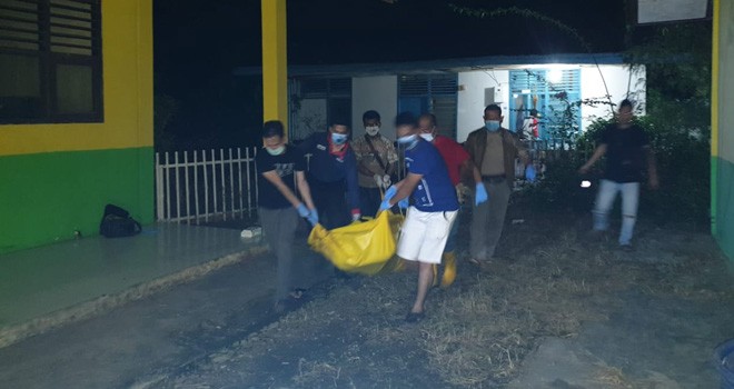 Petugas kepolisian melakukan evakuasi terhadap jasad Darmawan Ginting yang ditemukan telah membusuk di salah satu rumah dinas SDN 18 Tebo. Foto : Ist