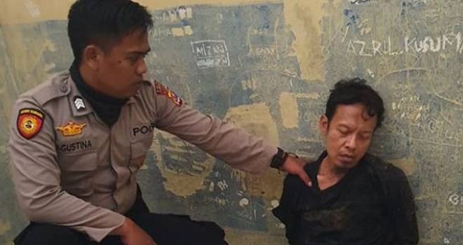 Anggota kepolisian mengamankan Syahril Alamsyah, terduga penusuk Wiranto. 