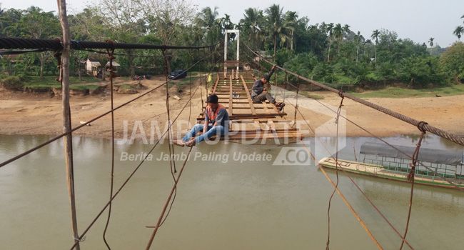 Warga sedang memperbaiki Jembatan Gantung di dusun Teluk Pandan, Bungo.