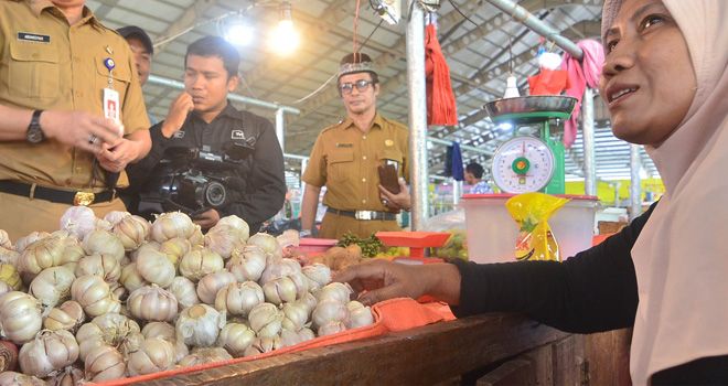 Pedagang di Pasar Angso Duo tengah menjual bawang putih. Distributor mengeluhkan menipisnya stok bawang putih karena ditahan im porter pusat.
