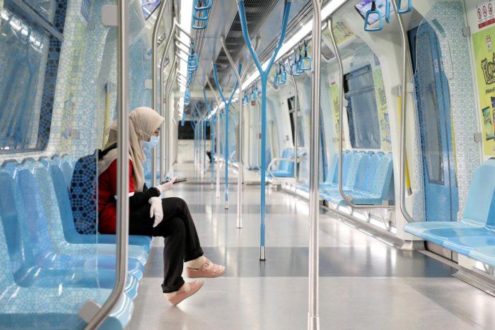 Seorang penumpang wanita sendirian di dalam gerbong kereta di Kuala Lumpur, Malaysia. Virus Corona di Malaysia masih belum sepenuhnya mampu dikendalikan.