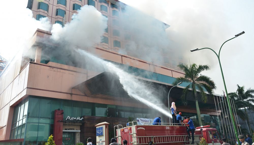 Petugas Pemadam dan Penyelamatan Kota Jambi memadamkan api yang membakar Hotel Novita dari atas mobil beberapa waktu lalu. Ini karena tidak memiliki armada tangga.

 