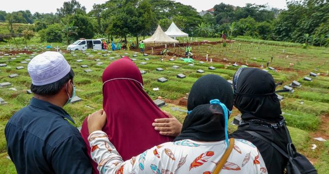 Anggota keluarga korban virus corona berduka saat pemakaman di Jakarta Selasa (31/3). 
