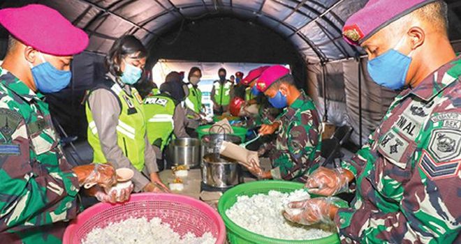 GOTONG ROYONG: Anggota Korps Marinir TNI-AL bersama anggota Polrestabes Surabaya membungkus makanan buka puasa untuk warga yang terdampak PSBB di dapur umum Jalan Rajawali kemarin (8/5). Ada seribu makanan siap santap yang dibagikan jelang berbuka dan sah. 