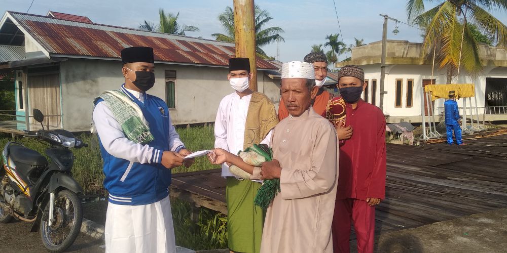 KNPI dan Pemuda Teluk Majelis saat membagikan masker ke pada warga yang hendak memasuki masjid.