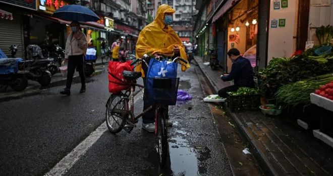 AKTIVITAS DI TENGAH KEKHAWATIRAN: Seorang pria yang mengenakan masker wajah datang untuk membeli sayuran di sebuah kios di Wuhan di Provinsi Hubei, kemarin (19/4). Setelah lockdown dibuka aktivitas kota itu pun terus menggeliat, meski tetap dibawah ancaman Corona.