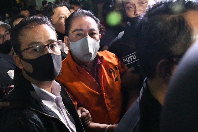 Anggota Bareskrim Mabes Polri mengawal tersangka tersangka korupsi, Djoko Tjandra selama kedatangannya di bandara Jakarta, Kamis (30/7) malam