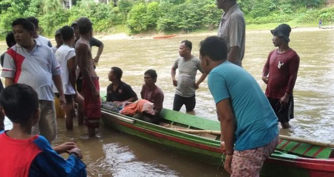 Warga Desa Teluk Kecimbung mengevakusi korban tenggelam.

