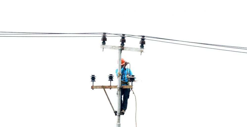 Petugas PLN sedang memperbaiki jaringan listrik.