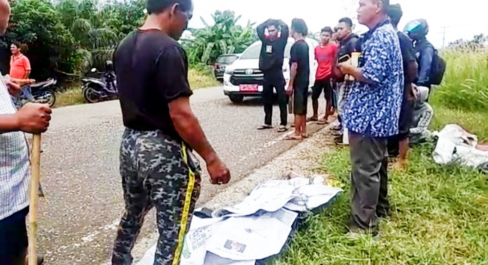 Pelajar yang tewas usai tabrak truk ditutupi dengan Koran sebelum dijemput mobil ambulan untuk dievakuasi ke Rumah Sakit.