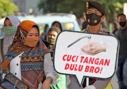 Petugas kepolisian melakukan sosialisasi protokol kesehatan, serta membagikan masker berwarna merah putih kepada masyarakat di Stasiun Tanah Abang, Jakarta, Kamis (27/8/2020). 