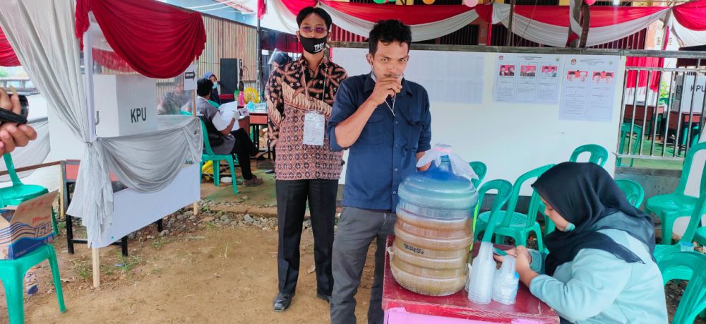 Warga Kelurahan Talang Babat, Kecamatan Muara Sabak Barat minum jamu sebelum masuk ke TPS. 