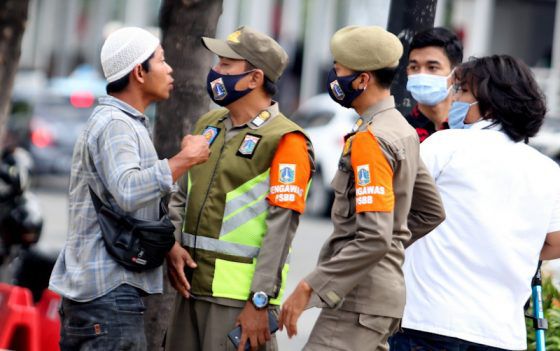 Petugas satpol PP beradu mulut dengan warga saat mengingatkan untuk mengenakan masked pada saat kampanye protokol kesehatan dikawasan MH Thamrin,Jakarta, Senin (30/11). 