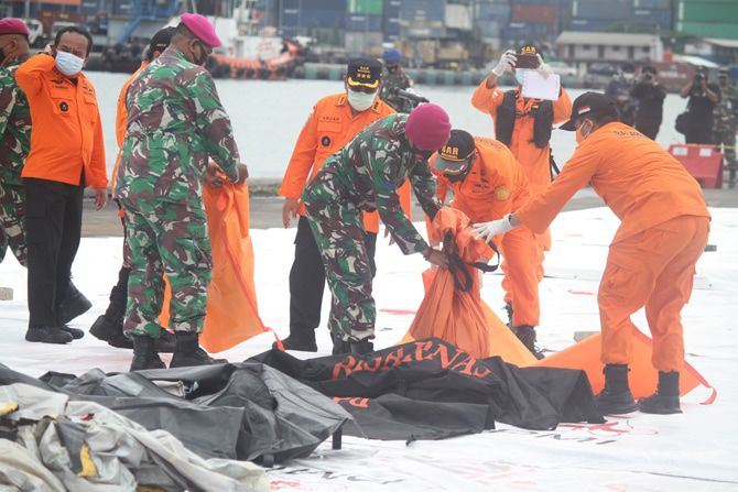 Petugas membawa kantong jenazah korban pesawat Sriwijaya Air SJ182.