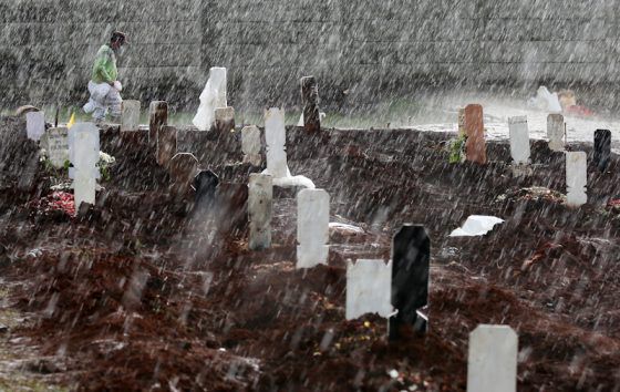 Petugas berjalan didekat makam COVID-19 di TPU Bambu Apus, Jakarta, Senin (25/1/2021). 
