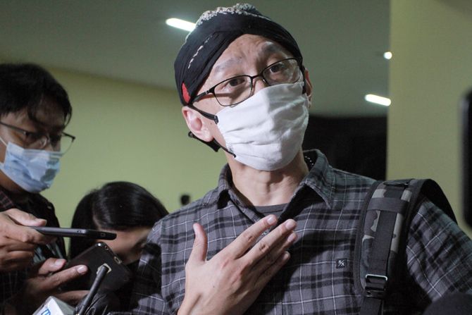Pegiat media sosial Permadi Arya alias Abu Janda berjalan keluar usai diperiksa penyidik Dit Tipidsiber Bareskrim Polri, Mabes Polri, Kebayoran Baru, Jakarta Selatan.