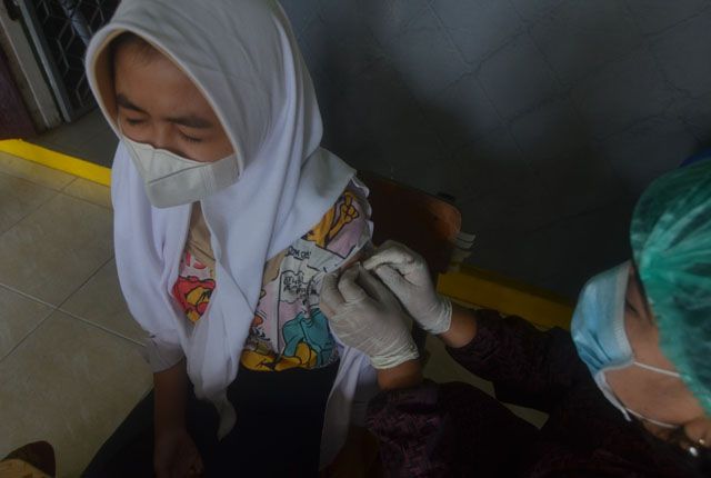 VAKSIN: Petugas melakukan vaksinasi terhadap pelajar yang sudah berusia 12 hingga 17 tahun di Kota Jambi.