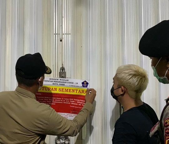 DISEGEL: Petugas melakukan penyegelan tempat usaha yang melakukan pelanggaran aturan selama pemberlakukan PPKM level 4.

