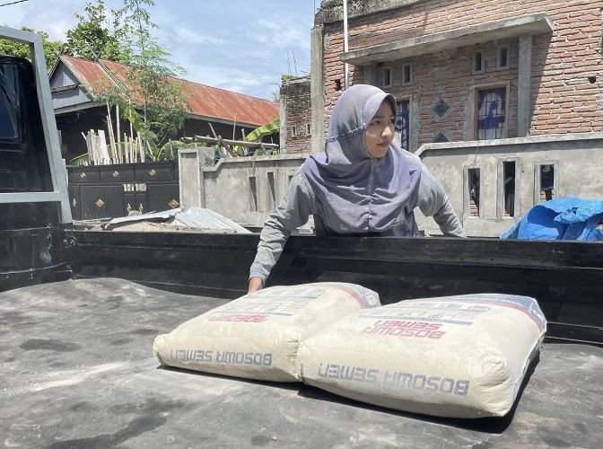 Nur Halisa saat mengangkut semen.