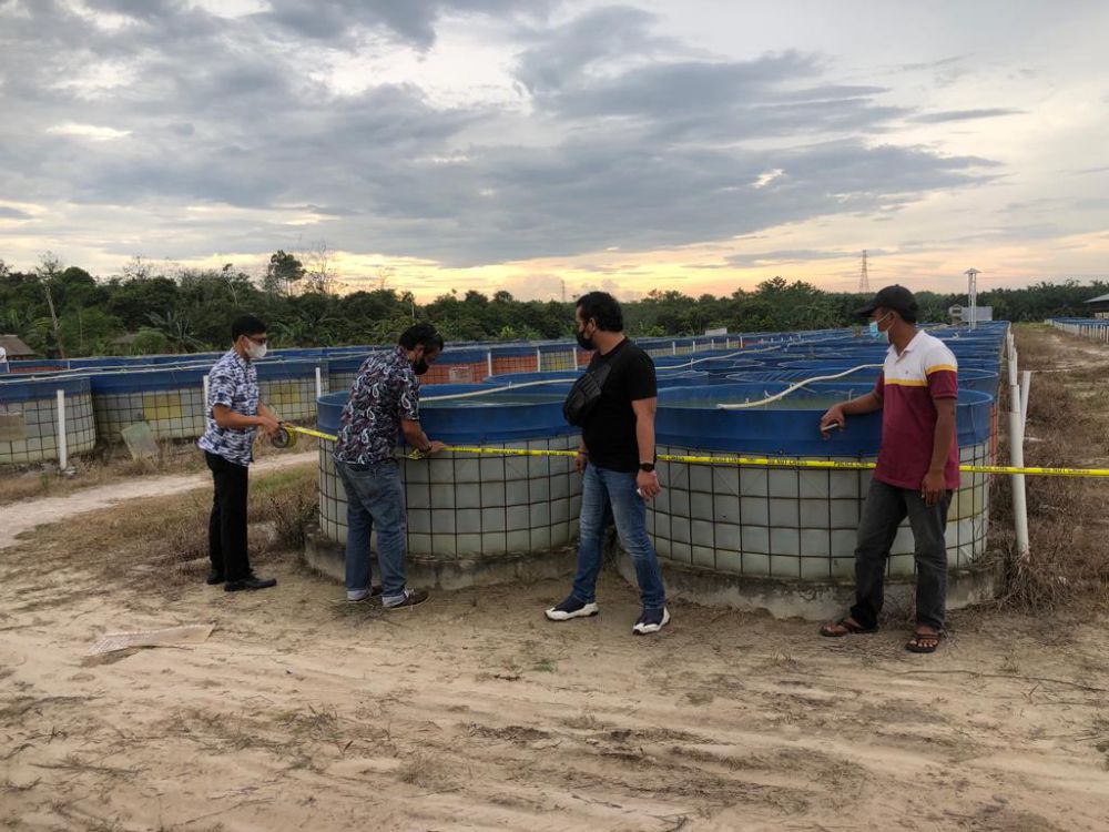 GARIS POLISI : Tim dari Ditreskrimum Polda Jambi memasang garis polisi menyita kolam Aset PT. DHD di Sungai Gelam, Muaro Jambi