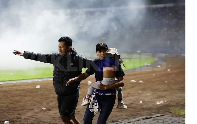 Potret mengharukan saat dua orang suporter menyelamatkan anak kecil di dalam stadion Kanjuruhan Malang.