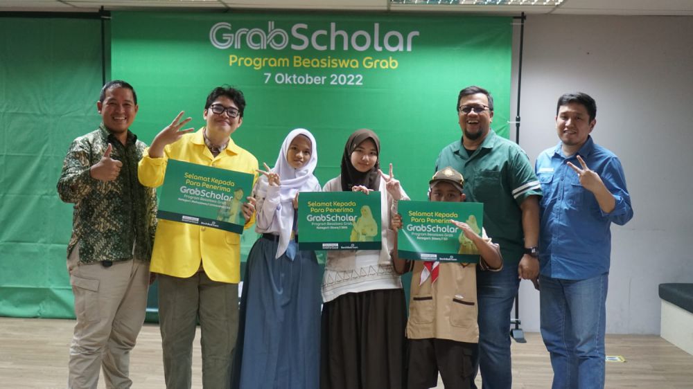 Penerima GrabScholar_ Program Beasiswa Grab 2022 kategori Mahasiswa_i Universitas (S1) bersama orang tua.