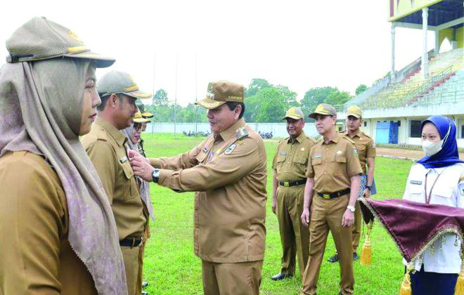 Penjabat Bupati Sarolangun Bachril Bakri saat memasang id card pegawai secara simbolis.