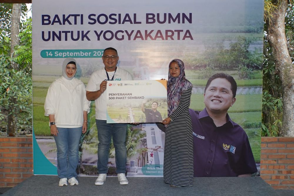 Direktur Compliance & Human Capital BSI Tribuana Tunggadewi (kiri) dan Asisten Deputi Bidang TJSL Kementerian BUMN Edi Eko Cahyono (tengah) saat memberikan simbolis bantuan 500 paket sembako pada Program Bakti Sosial BUMN kepada warga Desa Samberembe, Sleman, Yogyakarta (14/08).