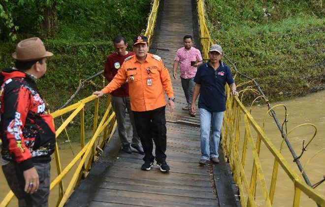 Pj Bupati Bachril Bakri saat melihat langsung jembatan gantung yang rusak di Kecamatan Batang Asai.