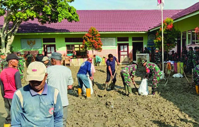 Anggota Koramil 417-03/ Air Hangat dan warga bergotong royong membersihkan sisa lumpur akibat banjir, di SD 109/III Desa Lubuk Suli Kecamatan Depati Tujuh, kabupaten Kerinci.