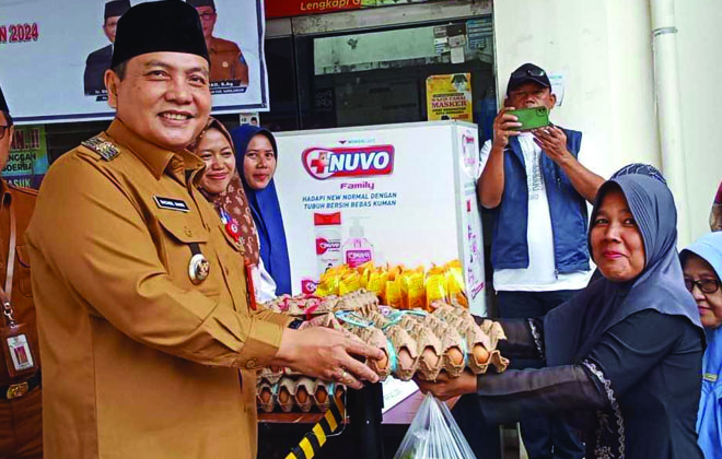 Pj Bupati Sarolangun, Bachril Bakri saat menyerahkan harga pangan subsidi kepada warga.