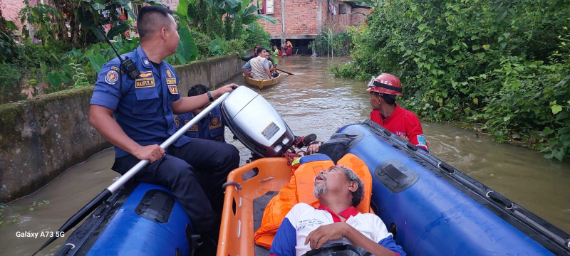 Tim penyelamatan Disdamkartan Kota Jambi saat melakukan evakuasi korban banjir yang sakit ditengah banjir, baru-baru ini.