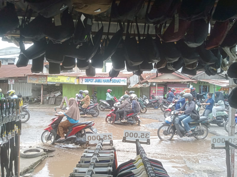 Terlihat air dari pasar tradisional simpang Empat Kebun Kopi mengalir ke badan jalan. 