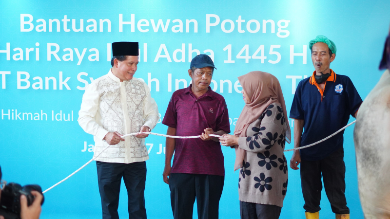 Direktur Utama BSI Hery Gunardi (kiri) menyerahkan secara simbolik hewan potong kepada duafa di Jakarta. (17/6)