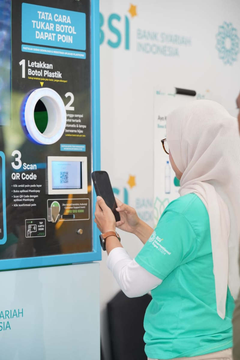 Pengunjung sedang memasukkan botol di mesin RVM (Reverse Vending Machine) mesin pengolah botol plastik