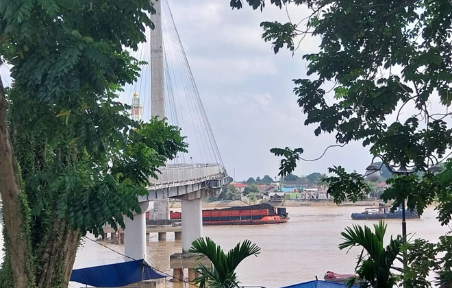 Tongkang batu bara saat melintas di bawah jembatan Gentala Arasy. Kini Sungai Batanghari sedang surut sehingga tongkang sulit melintas.