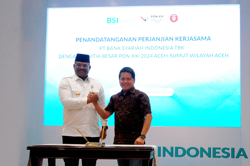 Direktur Utama BSI Hery Gunardi (kanan) berjabat tangan dengan (Pj) Gubernur Aceh Safrizal ZA pada seremoni penandatangan kerjasama antara BSI dengan PB PON XXI 2024 Aceh Sumut Wilayah Aceh yang berlangsung di  Gedung Landmark BSI Aceh, Selasa (10/9).