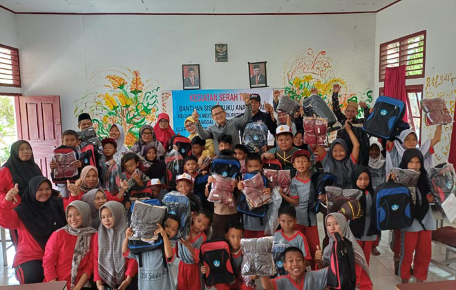 Usai menyerahkan bantuan seragam sekolah gratis di SD Negeri 238/IX Nyogan Sugandi Kecamatan Mestong Kabupaten Muaro Jambi,  Kepala Disdikbud Muaro Jambi Firdaus foto bersama.